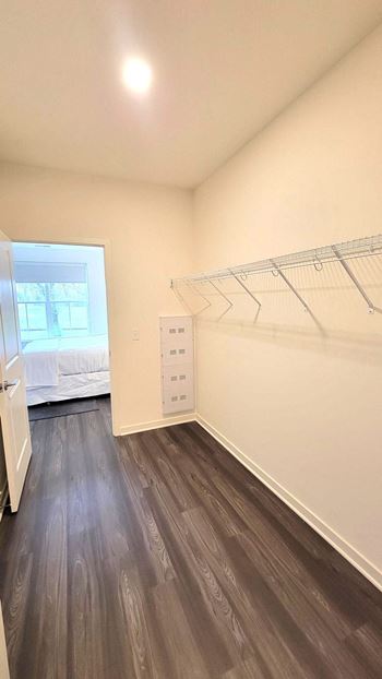 An empty bedroom with a closet and a window